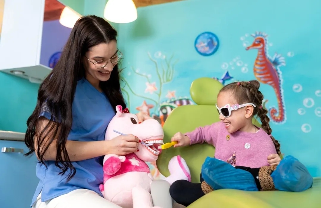 Medic stomatolog pediatru cu pacient copil in cabinet