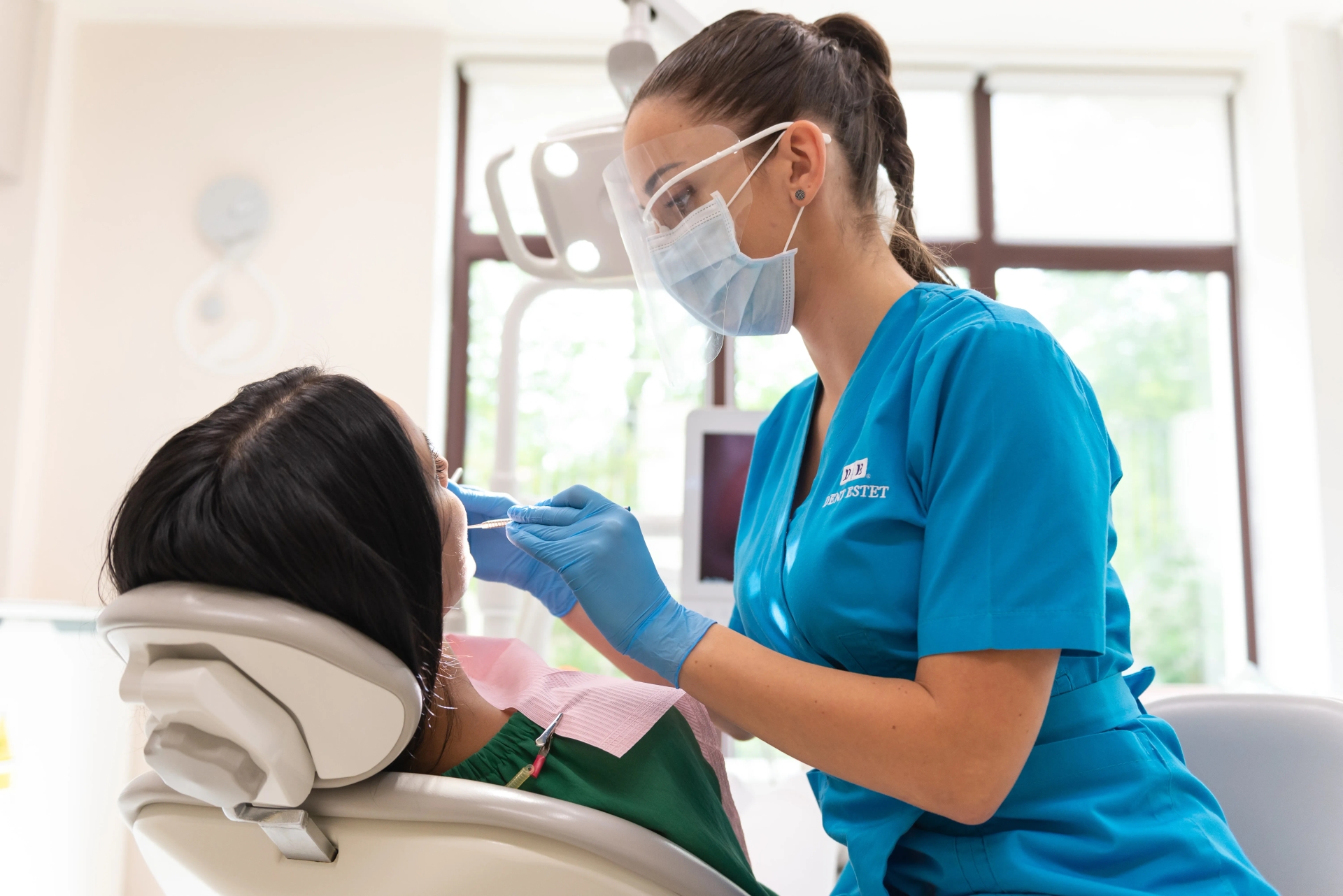 Medicul stomatolog consultă pacienta cu limba încărcată pentru a depista simptomele.