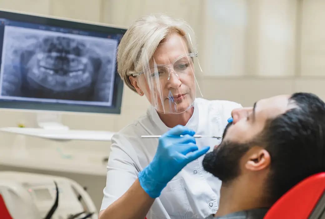 Medic stomatolog verifică implantul dentar.