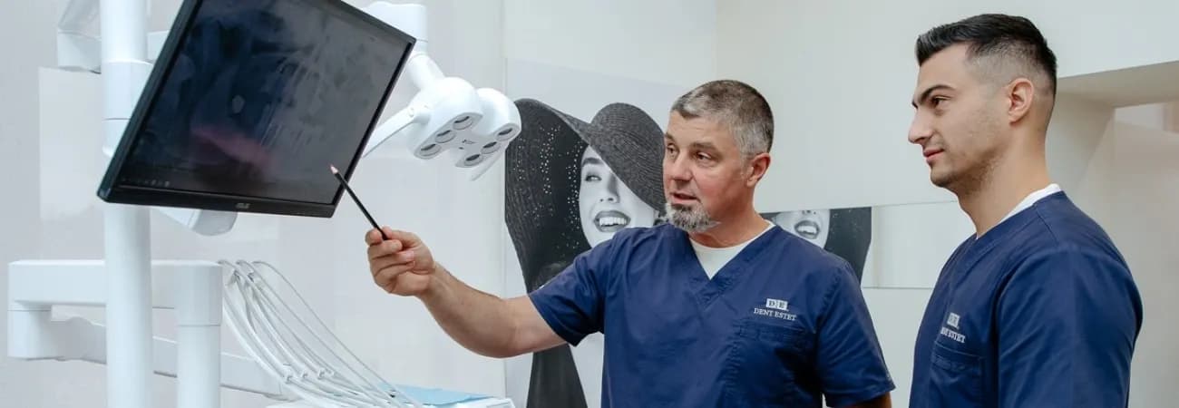 Medici implantologi se uita pe o radiografie cu implant dentar