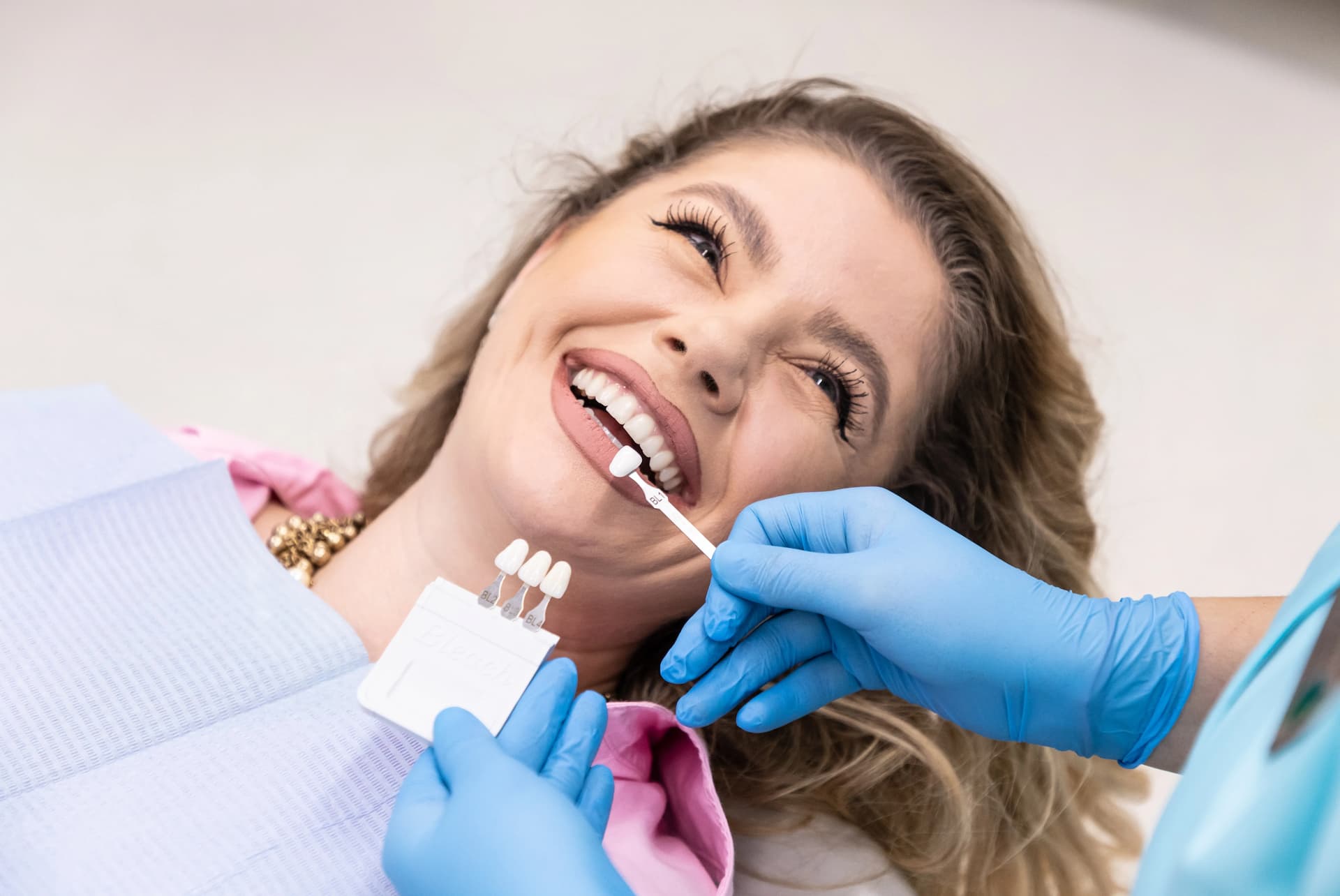 Pacienta discută cu medicul stomatolog care este nuanța de alb optimă pentru albirea dentară. 