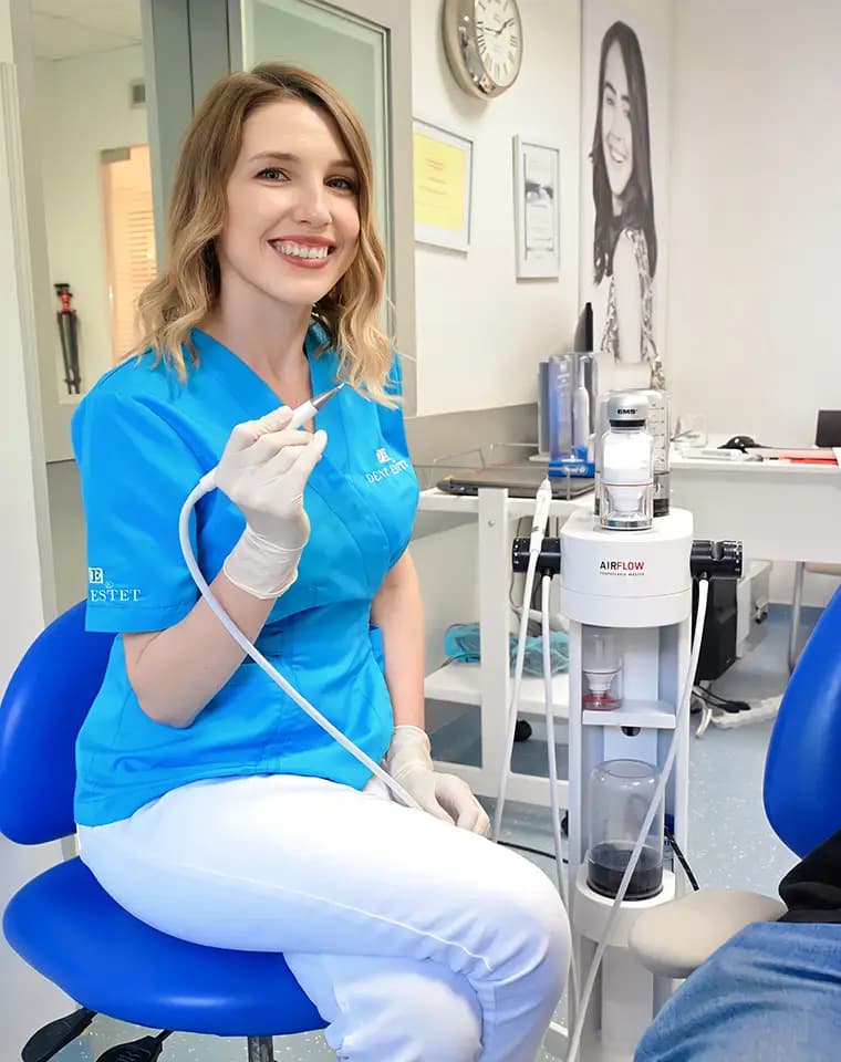 Medic stomatolog Dr. Cristina Stănescu realizează un detartraj cu Airflow.
